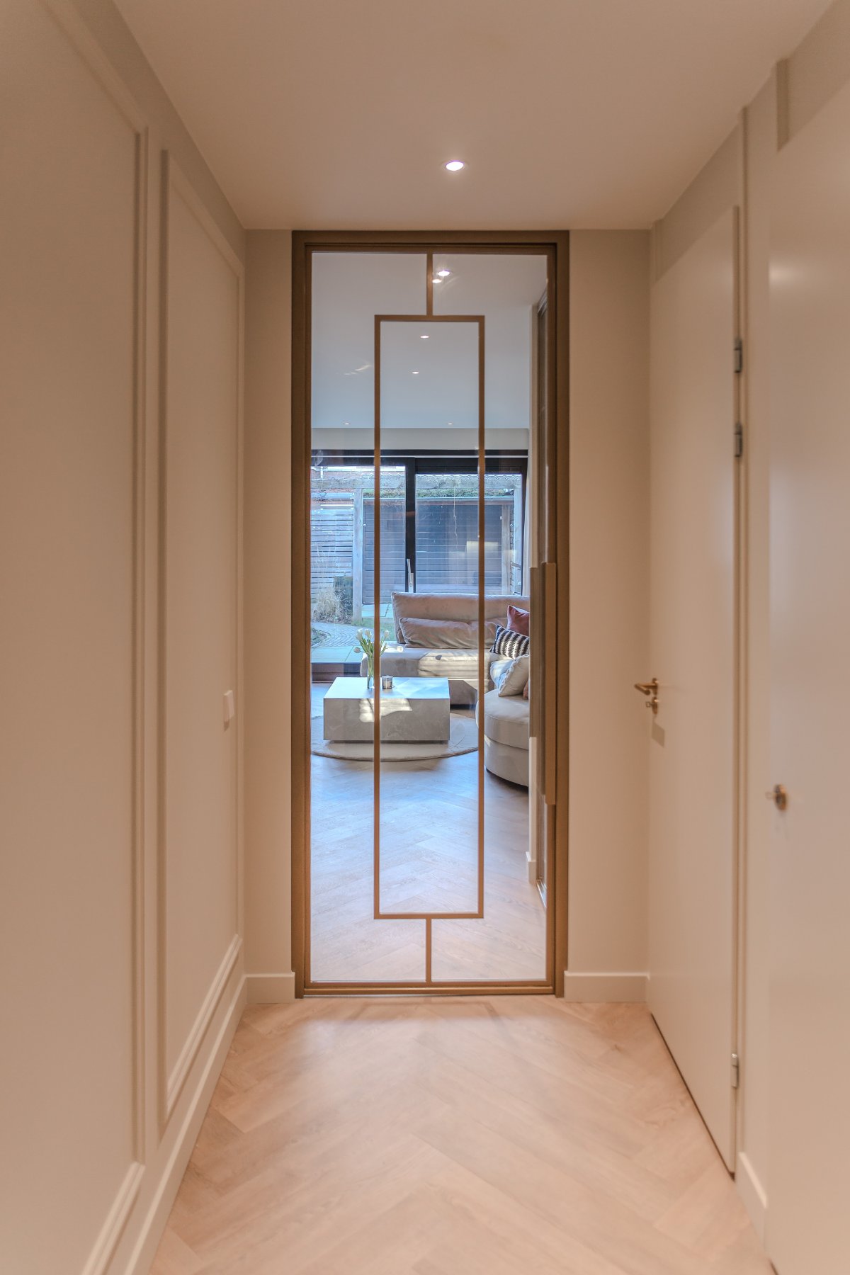 Zicht door de bronzen deur op de woonkamer