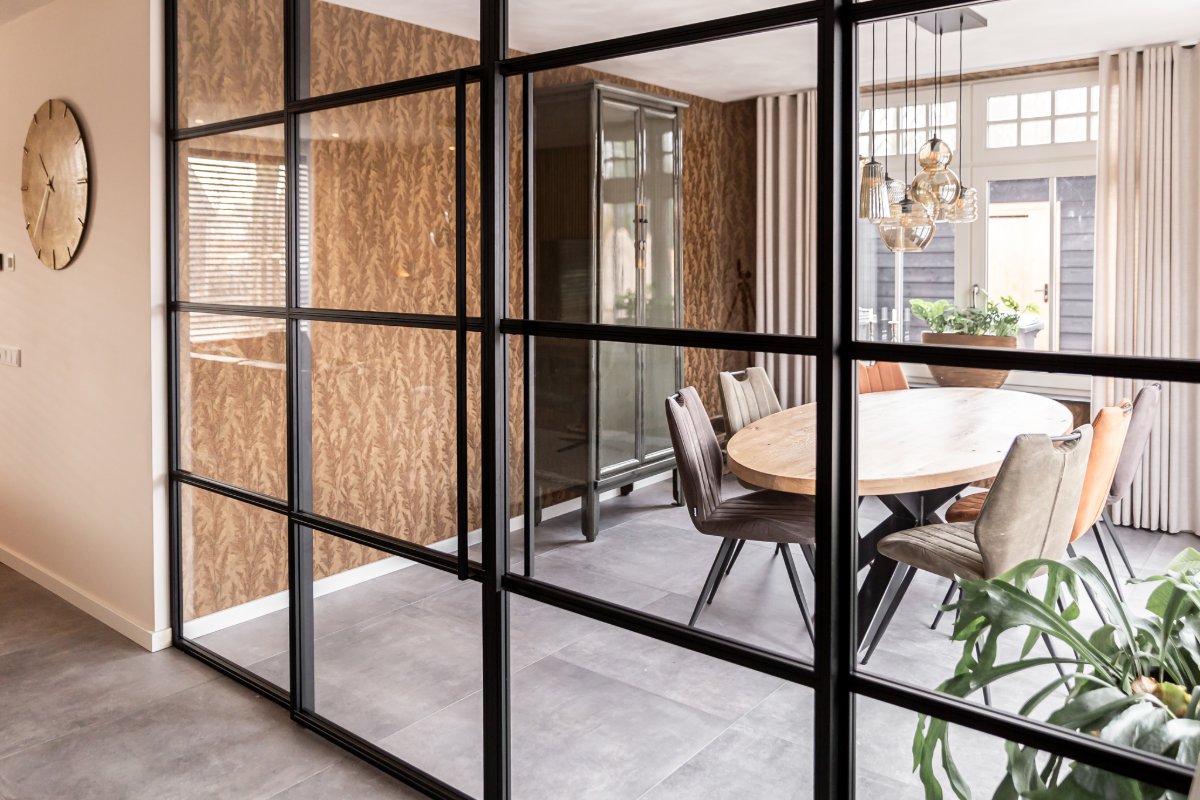 Zwarte glaswand in een kantoor met houten tafel