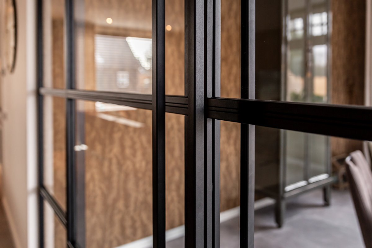 Detail van een zwart stalen profiel met glaslat