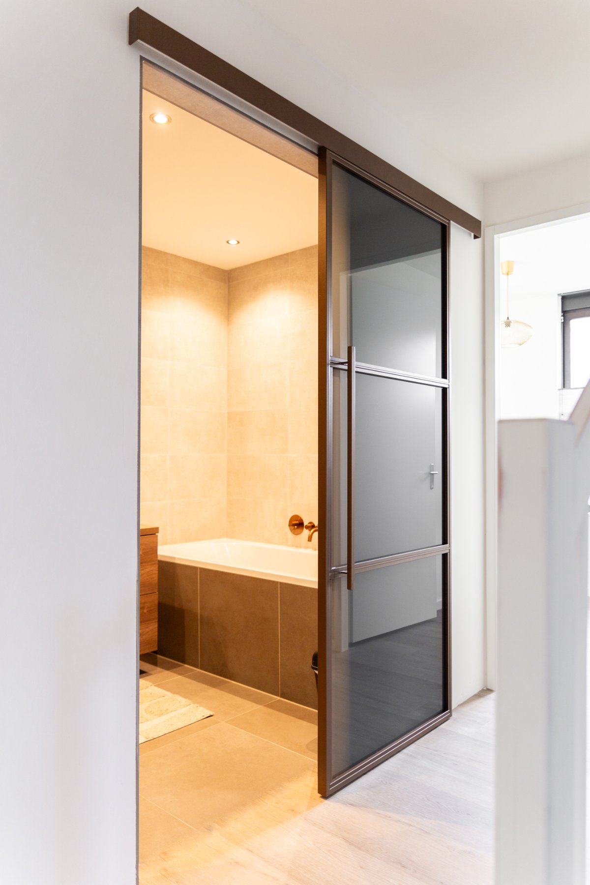 Stalen deur naar een badkamer met houten wand