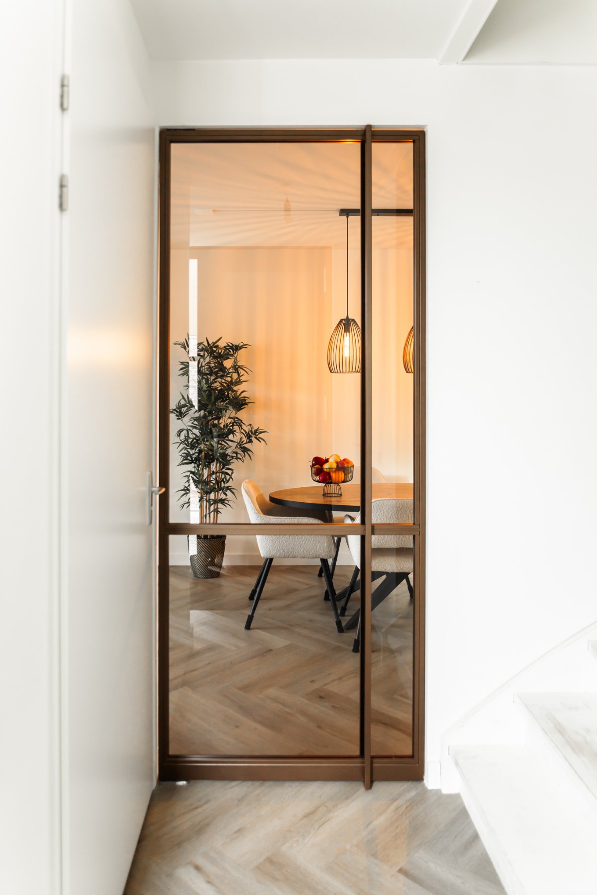 Stalen deur naar de eetkamer met hanglampen
